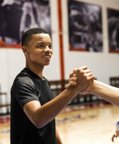 Group of teenager friends on a basketball court giving each other a high five